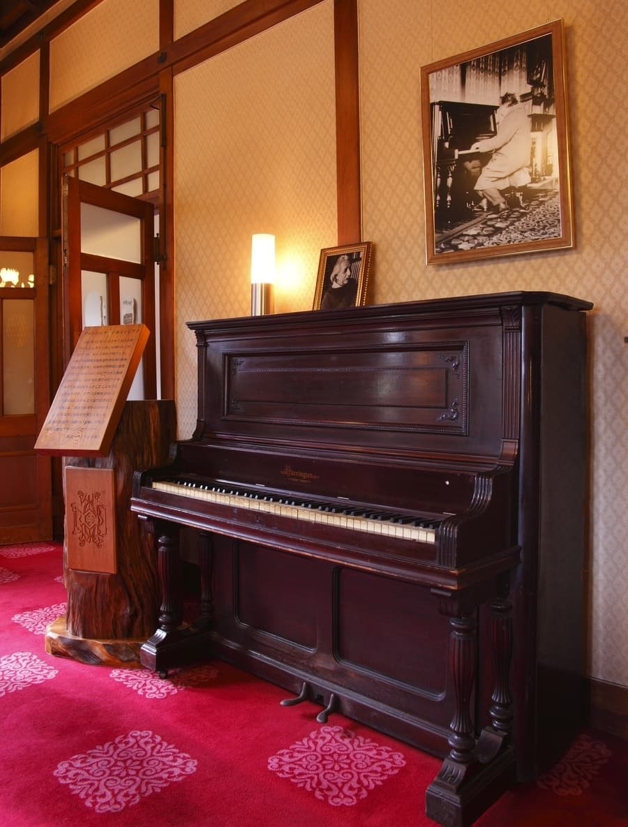「アインシュタインのピアノ」と呼ばれる奈良ホテルの米国製ピアノ。壁にはアインシュタインが実際に引いた姿を収めた写真が飾られています